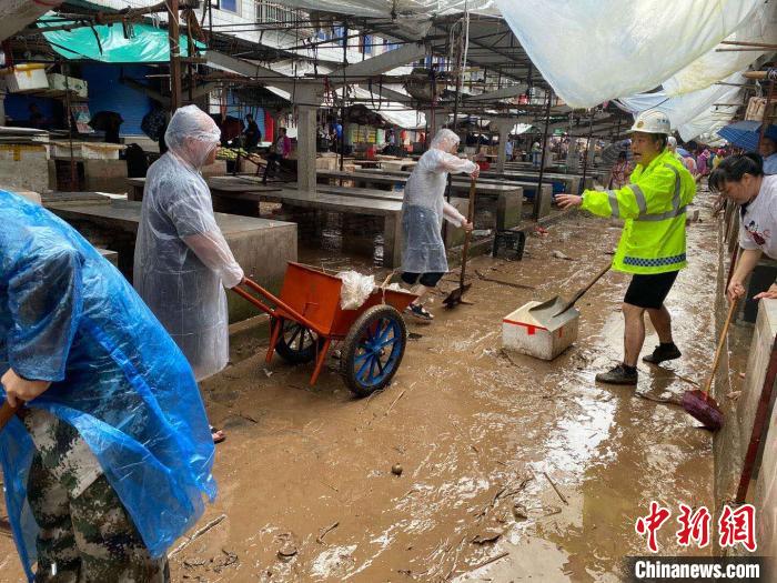 圖為7月26日，暴雨引發(fā)的洪水過境后，重慶萬州區(qū)分水鎮(zhèn)政府干部職工及志愿者清掃淤泥和垃圾。　　重慶萬州區(qū)委宣傳部供圖 攝